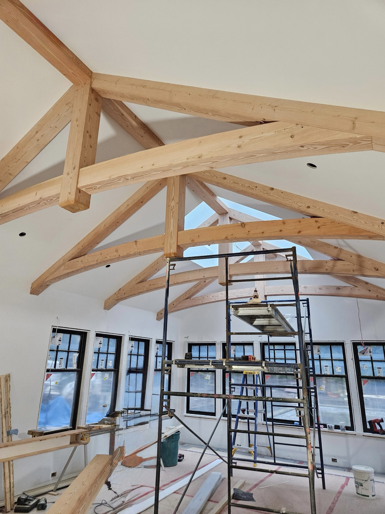 Vaulted great room with exposed custom timber-frame trusses and curved beams